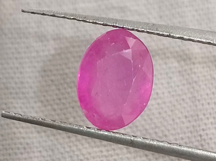 Natural untreated pinkish red ruby gemstone in oval shape, with good cut quality and clarity, measuring 7.96x5.94mm.
