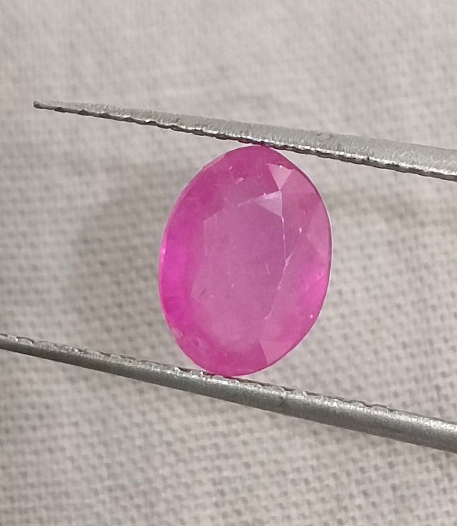 Natural untreated pinkish red ruby gemstone in oval shape, with good cut quality and clarity, measuring 7.96x5.94mm.