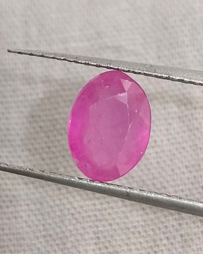 Natural untreated pinkish red ruby gemstone in oval shape, with good cut quality and clarity, measuring 7.96x5.94mm.