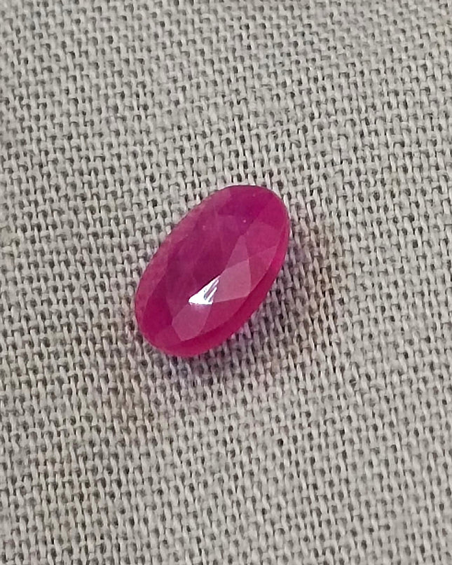 Natural untreated red ruby gemstone, oval-shaped, semi-transparent, good cut quality, measuring 6.96*4.93*2.91mm.