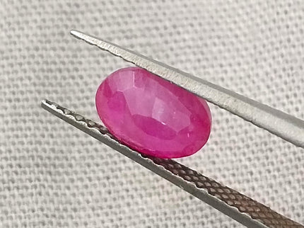 Natural untreated 1.00ct African ruby on tweezers, oval shape, red color, good cut quality, GSI certified.