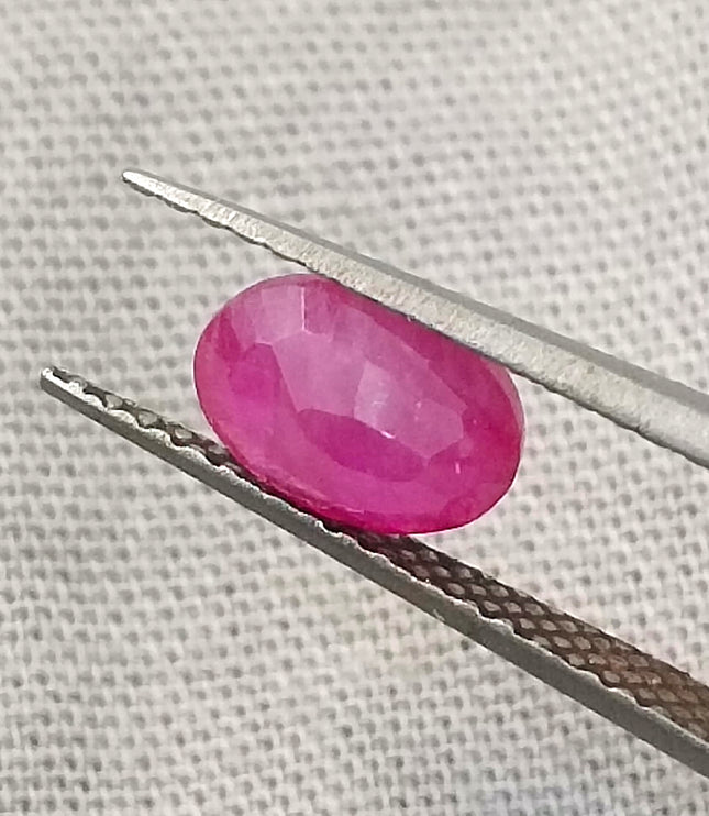 Natural untreated 1.00ct African ruby on tweezers, oval shape, red color, good cut quality, GSI certified.