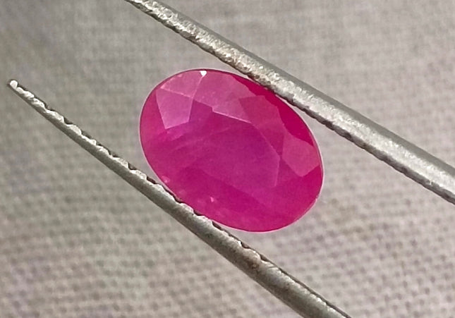 Natural untreated 1.00ct African ruby gemstone, oval shape, semi-transparent, vibrant red color, good cut quality.