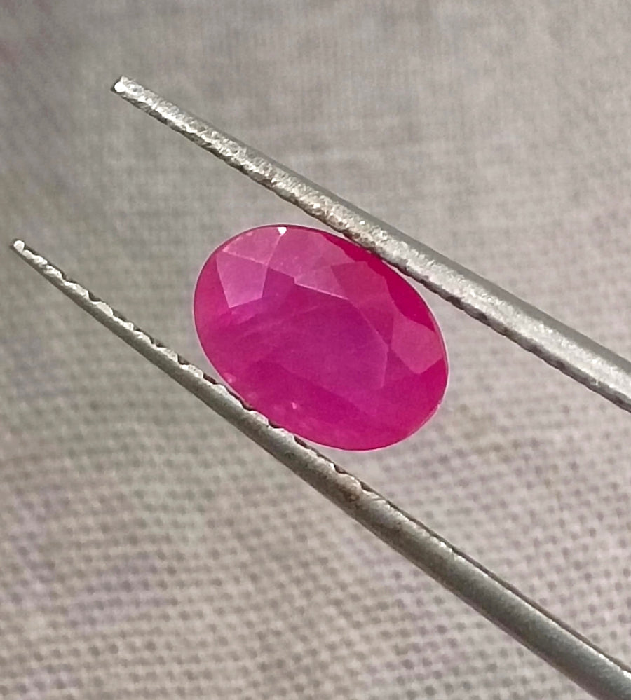 Natural untreated 1.00ct African ruby gemstone, oval shape, semi-transparent, vibrant red color, good cut quality.
